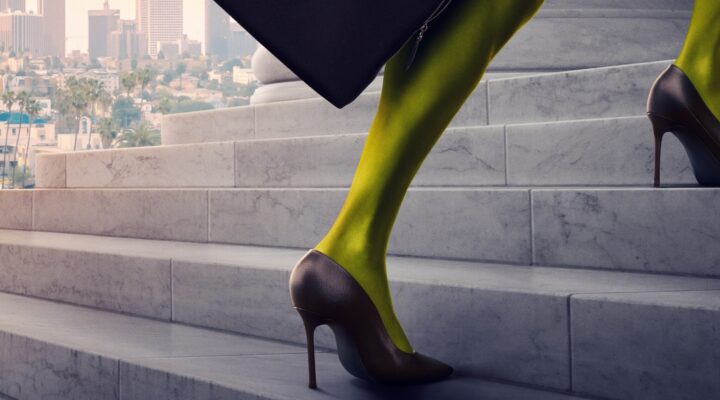 An image of a green leg in a high heel ascending the steps of a courthouse. Downtown LA is in the background.