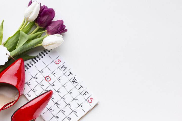 Photo of a red high heels, tulips and a calendar with the date 8 circled in red pencil.